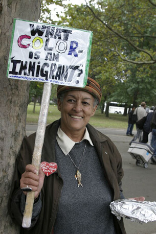 Stan Schnier, A woman at the Immigrant Workers Freedom Ride holds a sign that asks “What color is an immigrant?”, Flushing Meadows Corona Park, New York, New York, October 4, 2003. Stan Schnier, A woman at the Immigrant Workers Freedom Ride holds a sign that asks “What color is an immigrant?”, Flushing Meadows Corona Park, New York, New York, October 4, 2003.