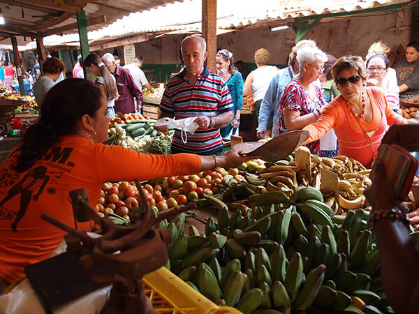 Charles D. Thompson, Jr., Osiris Cueto weighs produce for her customer at the Mercado Agropecuario Beleu. Old Havana, Cuba, December 2010. Charles D. Thompson, Jr., Osiris Cueto weighs produce for her customer at the Mercado Agropecuario Beleu. Old Havana, Cuba, December 2010.