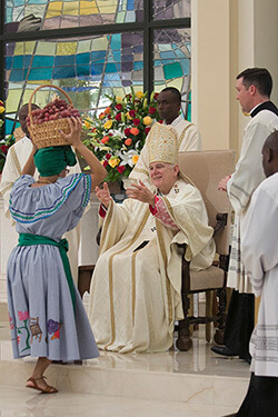 Archbishop Thomas Wenski receiving offertory gifts of fruits and native plants from parishioners, Notre Dame d'Haiti Catholic Church dedication service, Miami, Florida, February 1, 2015. Photo by Ana Rodriguez-Soto. Courtesy of the Archdiocese of Miami. Archbishop Thomas Wenski receiving offertory gifts of fruits and native plants from parishioners, Notre Dame d'Haiti Catholic Church dedication service, Miami, Florida, February 1, 2015. Photo by Ana Rodriguez-Soto. Courtesy of the Archdiocese of Miami.