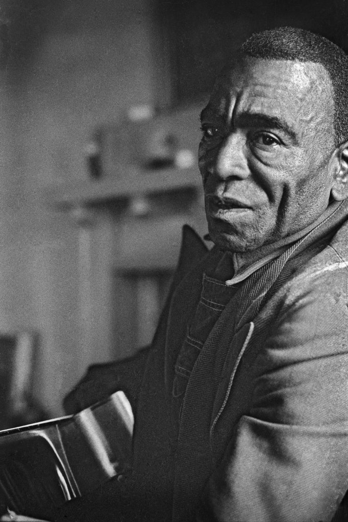 Green Paschal holding a guitar.