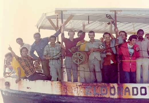 A boat crowded with Cuban refugees arrives during the 1980; Mariel Boatlift, Key West, Florida, ca. 1980