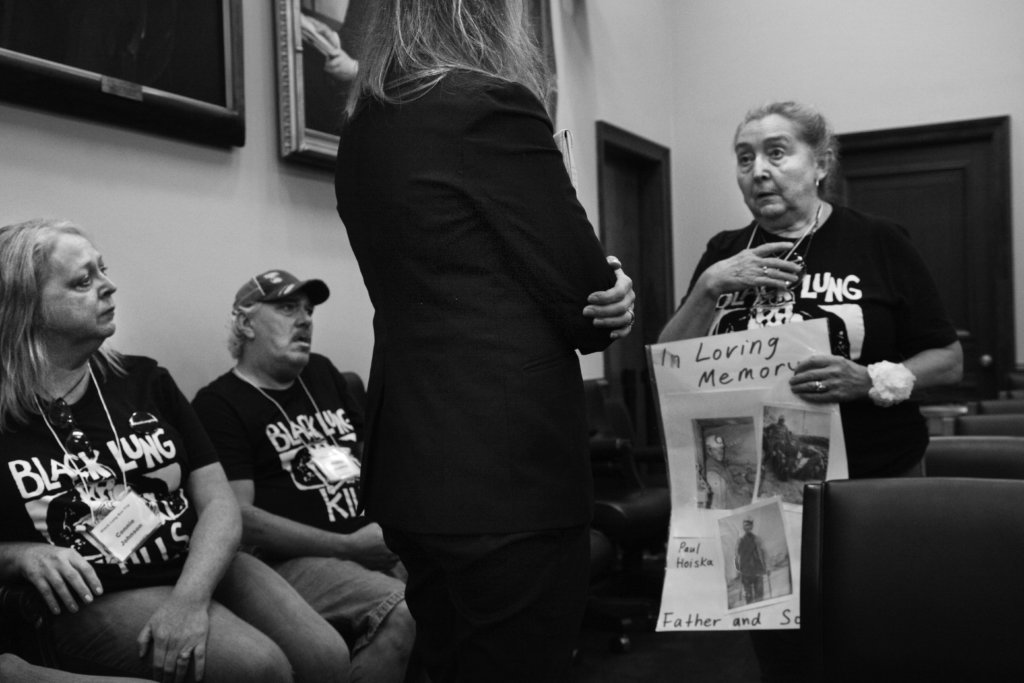 Kathy Hoiska, widow of Paul, who died in 2013 of black lung disease, tells her personal story of loss to a congressional staffer, Washington, DC, 2019. Photograph by and courtesy of Earl Dotter
