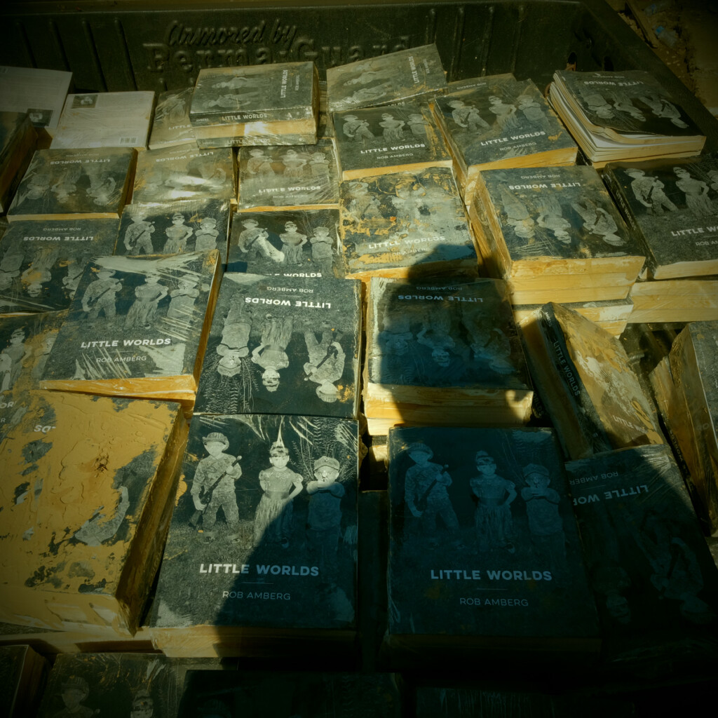 Flood-damaged books in the back of a pickup truck with shadow of the author.