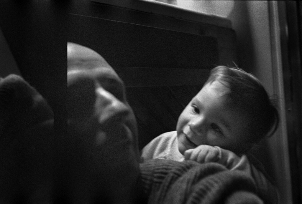 Photographer uses mirror to show himself and his young daughter.